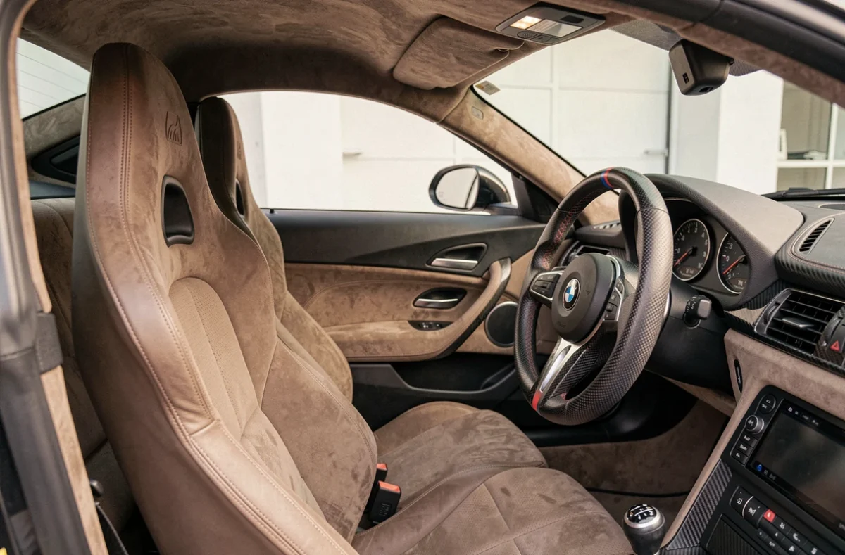 Intérieur de la BMW CSL avec siège baquet, volant carbone et instrumentation M sport dans un garage privé