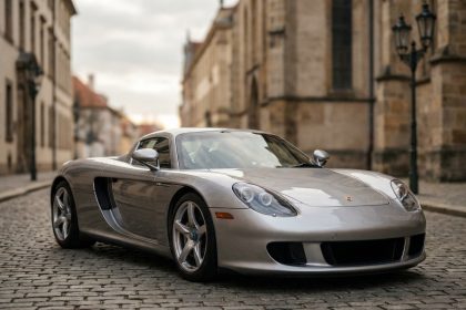 Porsche Carrera GT argent garée sur une rue pavée européenne, vue trois quarts avant